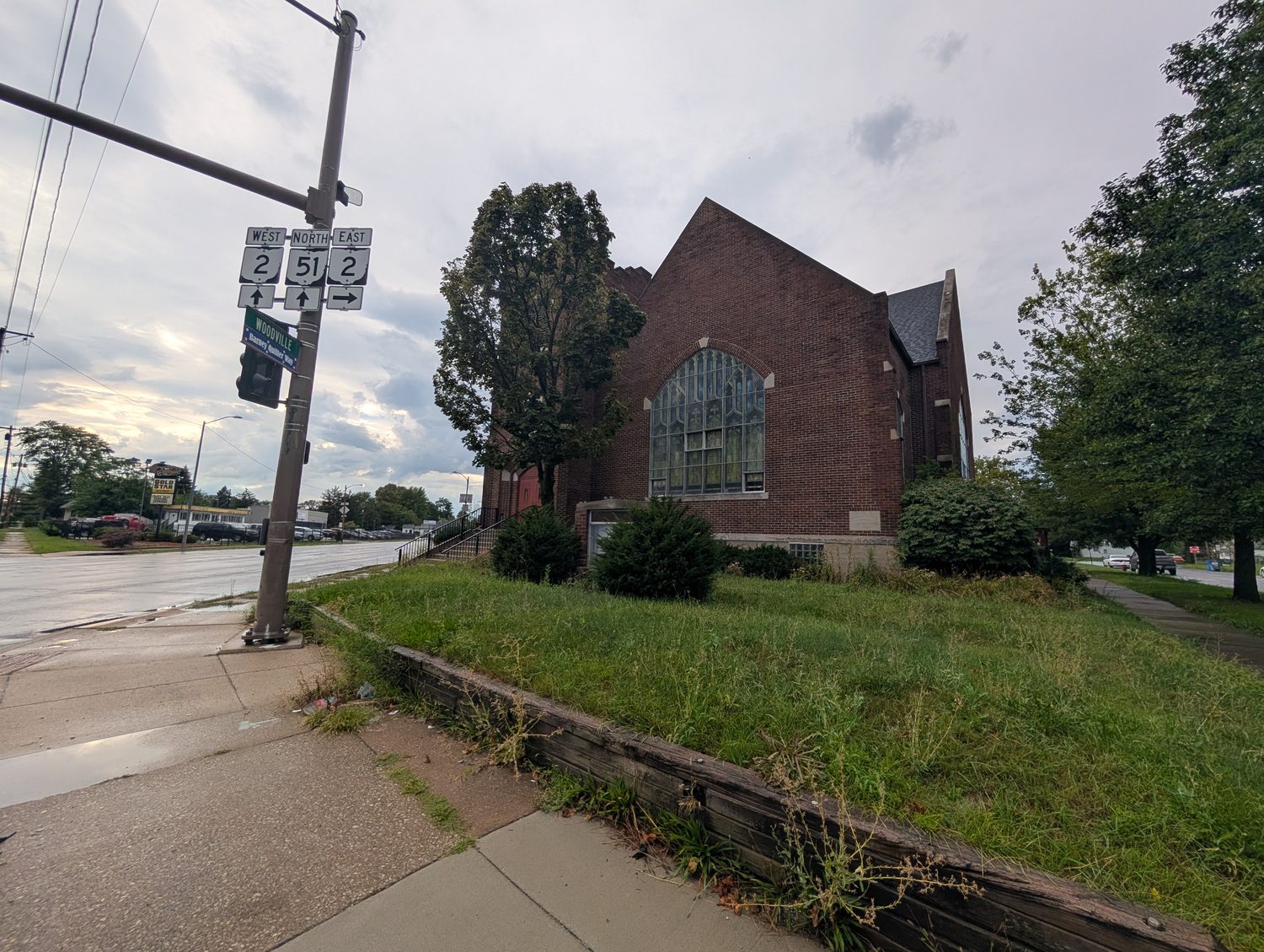 Eastminster United Presbyterian Church at Woodville Road and Navarre Avenue in East Toledo, with the route markers in the foreground. / La iglesia Eastminster United Presbyterian en Woodville Road y Navarre Avenue, en el este de Toledo, con las señales de ruta en primer plano.