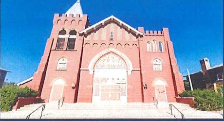 The former St. Agnes church on Martha Avenue, red brick with a central gable and pointed-arch entrance, photographed for the city’s 2025 landmark study / La antigua iglesia de St. Agnes en Martha Avenue, de ladrillo rojo con hastial central y entrada de arco apuntado, fotografiada para el estudio municipal de 2025