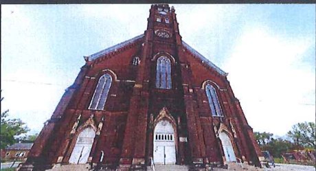 St. Anthony church, a tall red-brick Gothic façade with a central clock tower / La iglesia de St. Anthony, alta fachada gótica de ladrillo rojo con torre del reloj central